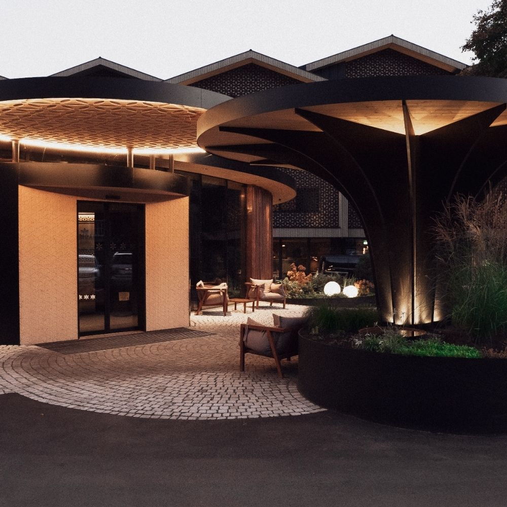 Außenfassade und Eingangsbereich des Designhotels AMRAI in Schruns in Vorarlberg mit moderner Architektur