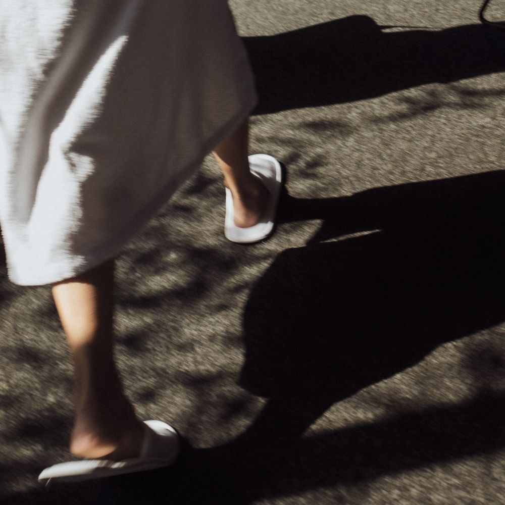 Person im Bademantel geht durch die Gänge des AMRAI in Schruns im Montafon im Wellnessbereich