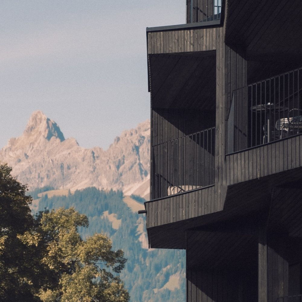 Außenfassade des AMRAI in Schruns in Vorarlberg mit Bergen im Hintergrund und moderner Architektur